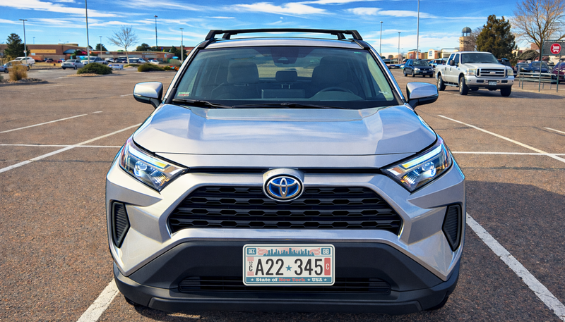 Silver Toyota SUV parked in a parking lot with a clear sky.