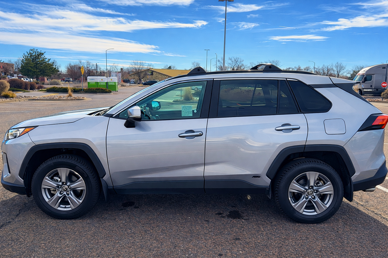 Silver SUV parked in a parking lot with a clear sky